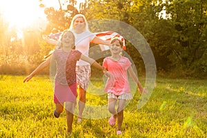 happy family with the flag of america USA at sunset outdoors