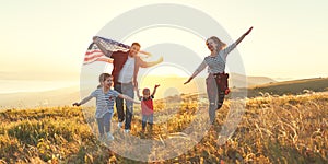 Happy family with flag of america USA at sunset outdoors