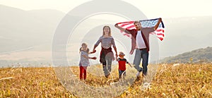 Happy family with flag of america USA at sunset outdoors