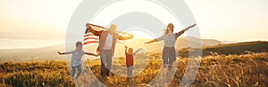 Happy family with flag of america USA at sunset outdoors