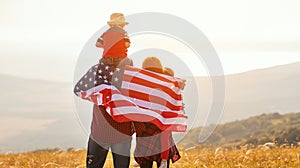 Happy family with flag of america USA at sunset outdoors