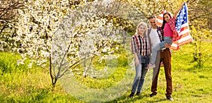 happy family with the flag of america USA at sunset outdoors