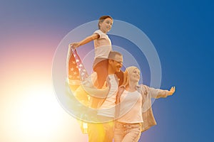 happy family with the flag of america USA at sunset outdoors