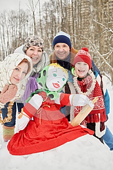 Happy family of four around stuffed dummy