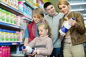 Happy family of four buying pasteurized milk photo