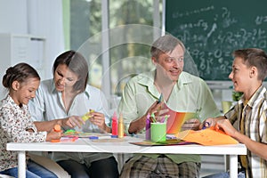 Happy family of four drawing together at home