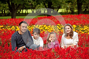 Happy family of four in flowering park