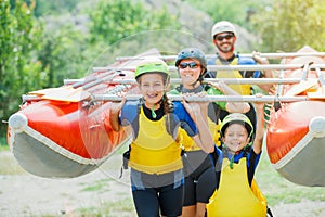 Happy family of four in helmet and live vest ready for rafting on the catamaran