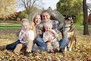 Happy Family of Four People and Dog OUtside in Autumn