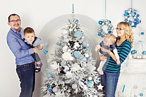 Happy family of four persons decorating christmas tree