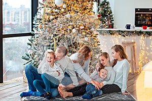 Happy family near the Christmas tree with the present boxes photo