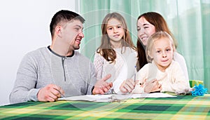 Happy family of four signing documents