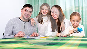 Happy family of four signing documents