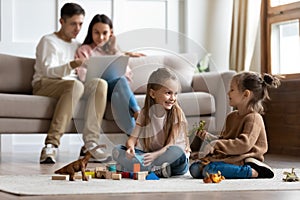 Happy family of four spending leisure time in living room.