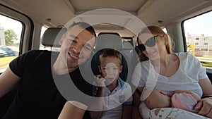 Happy family of four traveling by car