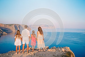 Happy family of four walking in the mountains on the sunset