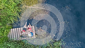 Happy family and friends fishing together outdoors near lake in summer, aerial top view