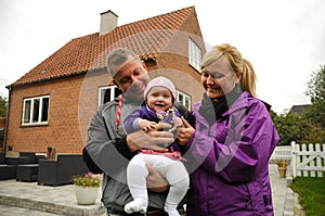 Happy family in front of house