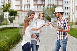 Happy family in front of new apartment building