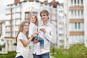Happy family in front of new apartment building