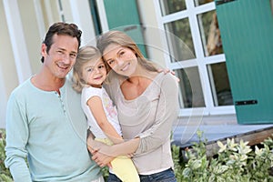 Happy family in front of their new home