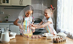 Happy family funny child sisrets twins bake kneading dough in kitchen