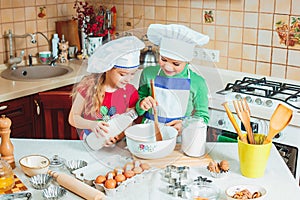 Happy family funny kids are preparing the dough, bake cookies in the kitchen