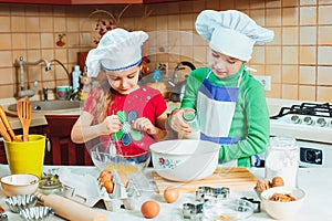 Happy family funny kids are preparing the dough, bake cookies in the kitchen