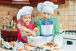 Happy family funny kids are preparing the dough, bake cookies in the kitchen