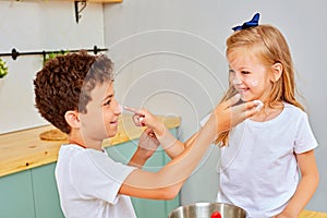 Happy family funny kids are preparing the dough, playing with flour in the kitchen