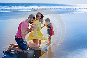 Happy family funny picnic on sand beach with sea surf