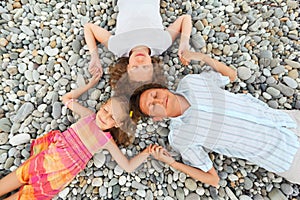 Happy family with girl lying on beach, closed eyes