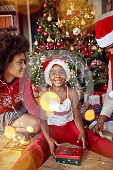 Happy family- girl opens a gift for Christmas morning