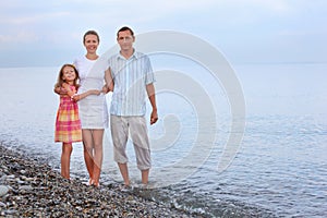 Happy family with girl standing on beach