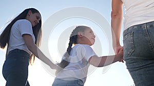 Happy family goes for a walk in the park on sunset. daughter holds mom and. father daddy mother parents and little baby