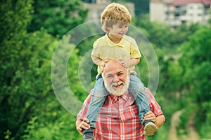 Happy family - grandfather and child on meadow in the summer on the nature. Happy joyful grandfather having fun throws