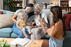 Happy family. Grandmother, mother, aunt and little baby having fun at home. Relatives visiting new born child