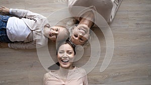 Happy family grandmother mother and preteen girl lying on floor