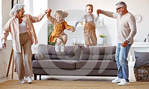 Happy family grandparents and grandchildren having fun playing together on weekend at home