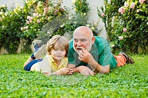 Happy family Grandson hugs his grandpa on holiday. Family summer and active holidays. Grandfather with son in park