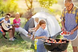 Happy family grilling meat on a barbecue