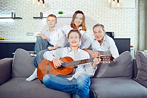 Happy family with guitar singing songs in the room.