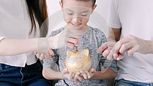 Happy family hands holding piggy bank. kid and parents put coins into piggy bank