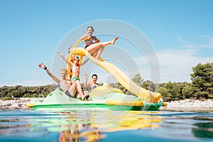 Happy family hands up on floating Playground slide Catamaran as they enjoying sea trip durins summer vacation