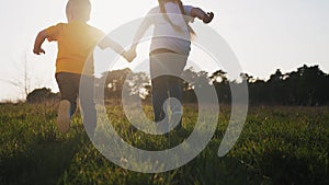 happy family. happy family childhood dream concept. children silhouette hold hands run through the grass in the park in