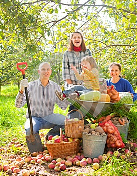 Happy family with harvest in garden
