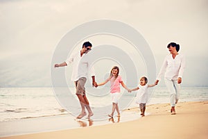 Happy Family have Fun Walking on Beach at Sunset