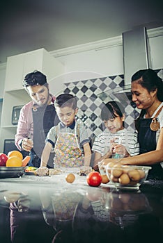 Happy family have a good time cooking together in the kitchen at home.