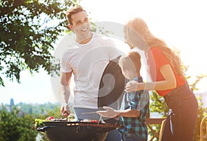 Happy family having barbecue with grill outdoors on sunny day