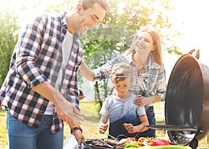 Happy family having barbecue with grill outdoors on sunny day